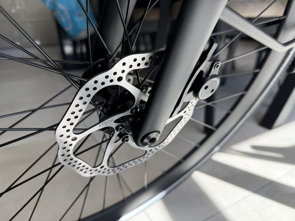 Close-up of the front disc brake assembly of the Tezeus C8