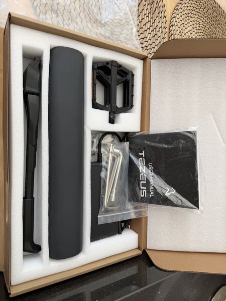 Inside of the original Tezeus box showing user manual, pedals and accessories packed in original foam